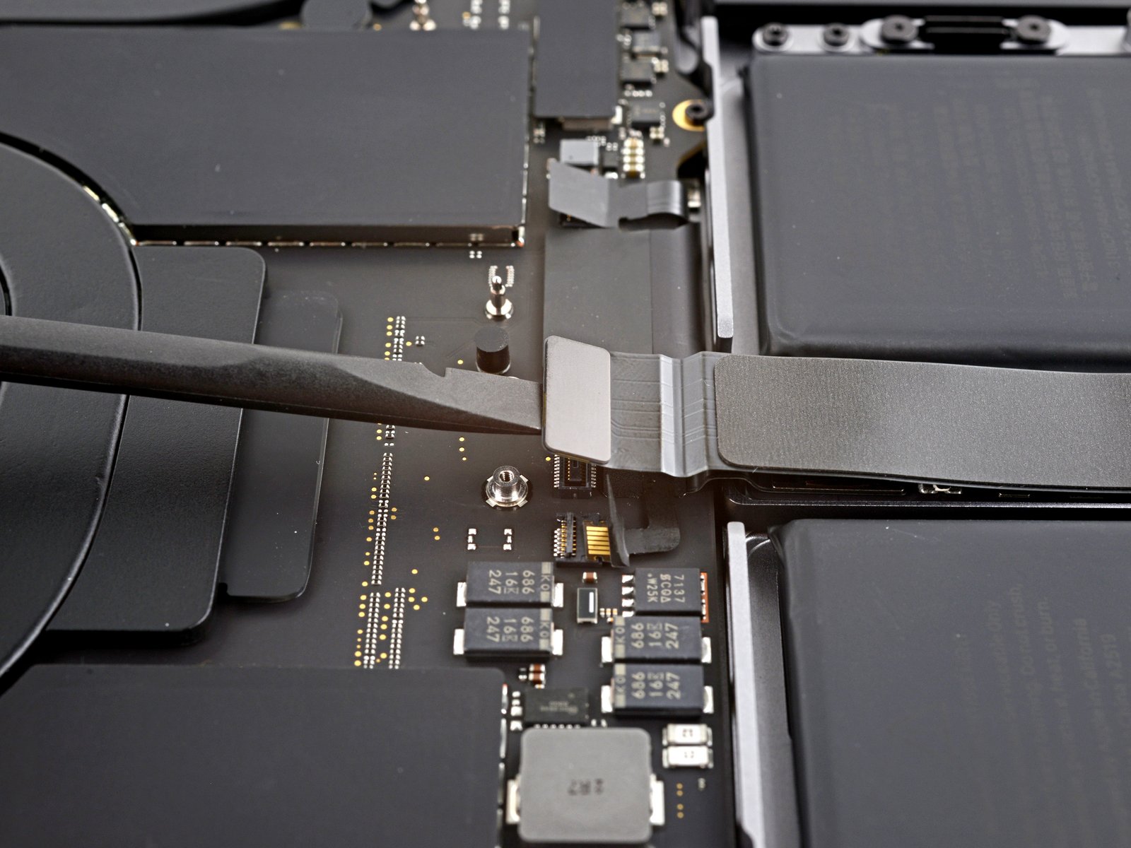 changer écran MacBook Pro 14 pouces 2021 A2442 - déconnexion de la nappe trackpad au spudger vue 2